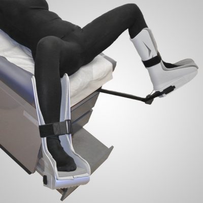 Model laying on table with feet rested in GStirrup with foam foot pads.